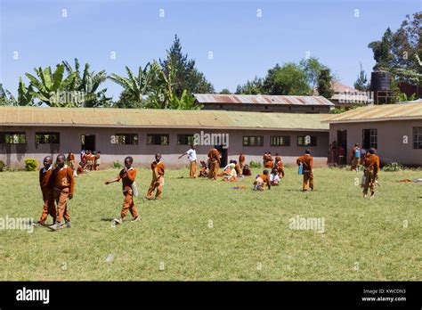 Children In Uniforms Playing In The Cortyard Of Primary School In Rural