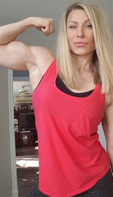 a woman flexing her muscles in front of the camera with one arm behind her head