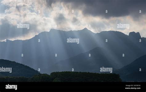 Bright Sunlight Shining Through Hole Of Clouds To Dark Scene Of