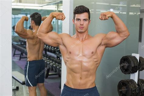 Shirtless Muscular Man Flexing Muscles In Gym Stock Photo By Wavebreakmedia