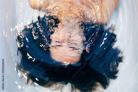 woman holding breath underwater in the bathtub stock foto adobe stock