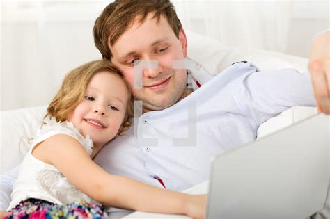 happy dad and daughter with laptop — photo — lightstock