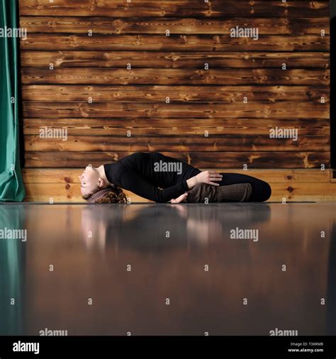 Woman Practicing Yoga Lying In Reclining Hero Exercise Supta Virasana