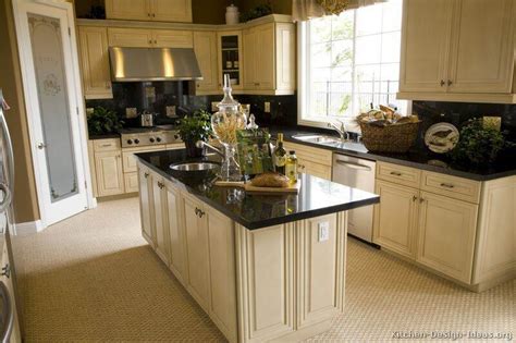Antique white cabinets paired with black appliances for modern look. Antique White Kitchen Cabinets With Black Granite ...