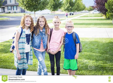 Four School Kids Heading Off To School In The Morning Stock Photo