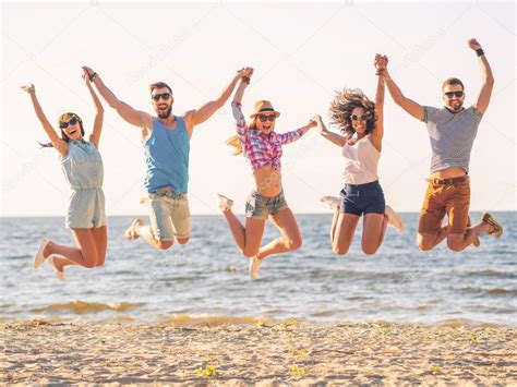 Happy Young People Jumping On Beach Stock Photo By ©gstockstudio 75407051