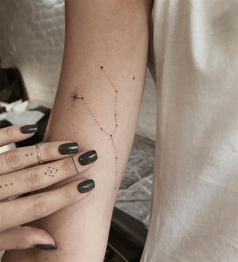 A Woman S Arm With Stars On It And Her Hand Holding The Other Arm
