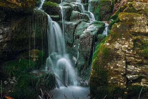 Flowing Waterfall Over Mossy Boulders In Green Forest By Stocksy