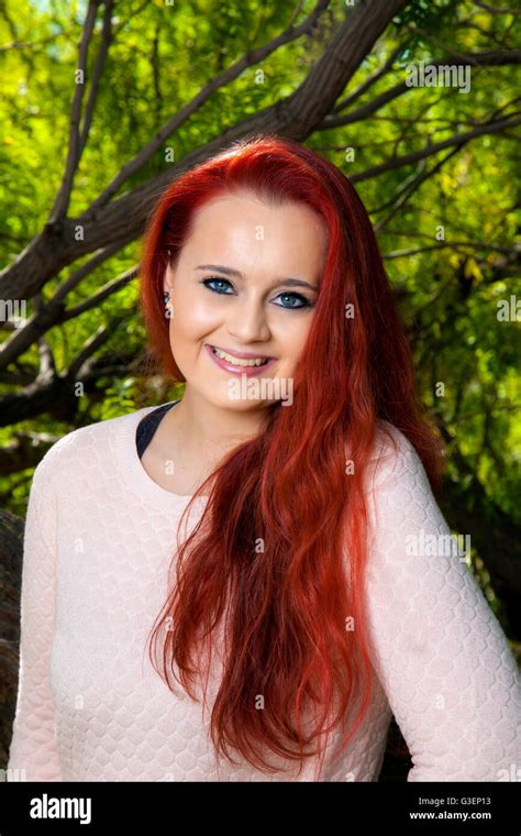 A Beautiful Teenage Girl With Dyed Red Hair Poses For A Portrait In
