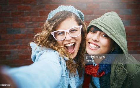 Two Beautiful Girls Take Playful Smiling Selfie Outdoors High Res Stock