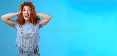 excited amused joyful redhead curly girl having amazing perfect news touch hair astonished stare