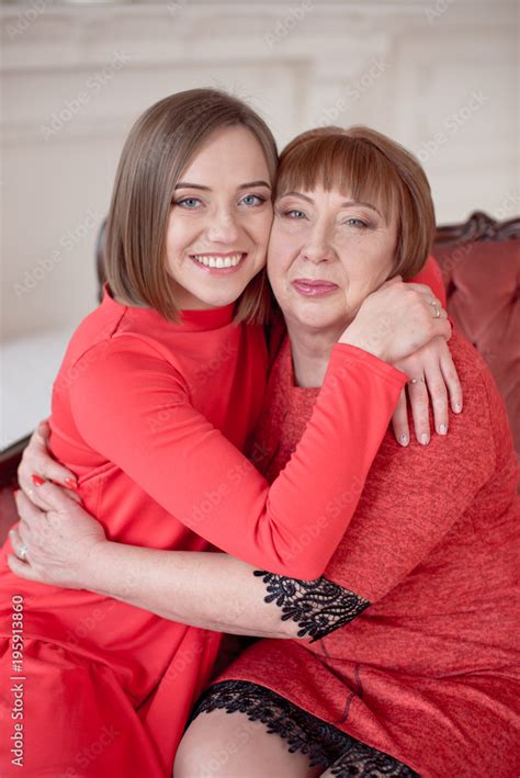 Mature Mother And Daughter Hugging Each Other In Vintage Big Red
