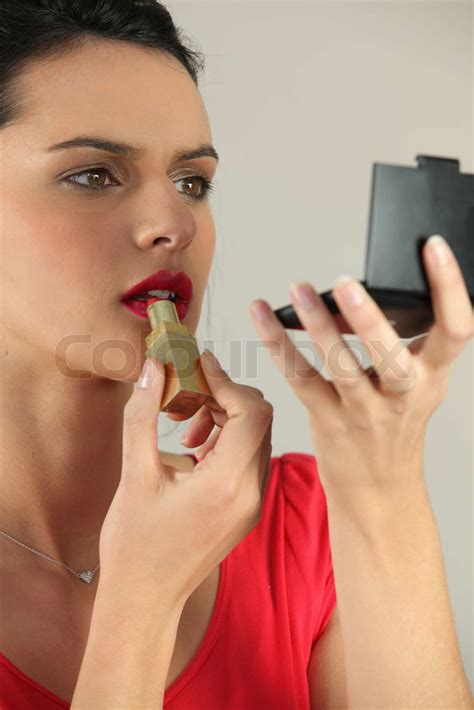 Young Woman Putting On Lipstick Stock Image Colourbox