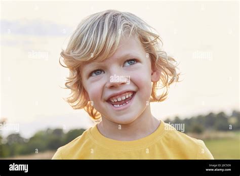 Portrait Of Blond Haired Blue Eyed Boy On Playing Field Stock Photo