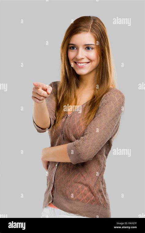 Beautiful Blonde Woman Pointing Somewhere Isolated Over A Gray