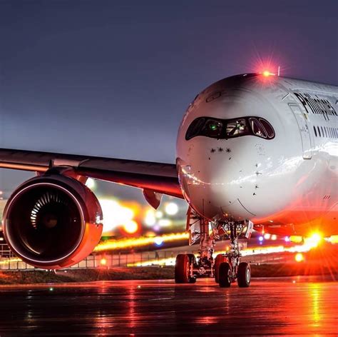 An Airplane On The Runway At Night With Lights Coming From Its Engines