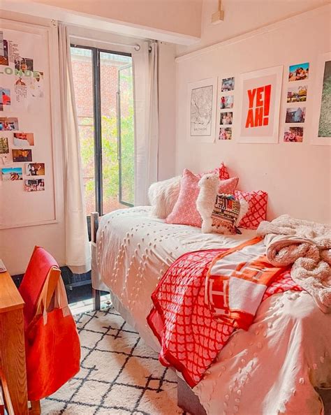 an orange and white bedroom with pictures on the wall