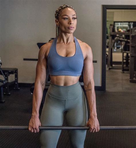 A Woman Is Standing In The Gym Holding A Bar