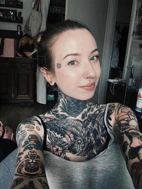 A Woman With Tattoos On Her Chest And Arm