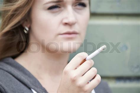 Close Up Of Teenage Girl Smoking Cigarette Outdoors Stock Image