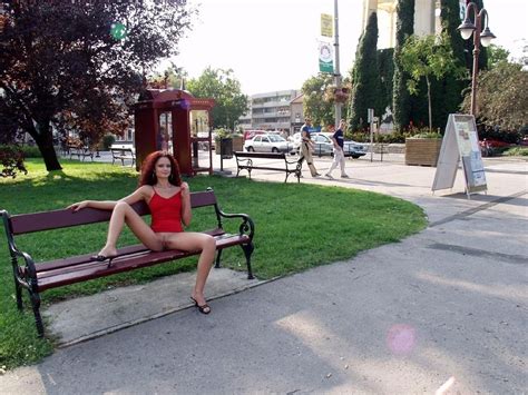 In A Park In A Short Dress And Daringly Showing Her Bottomless Pussy