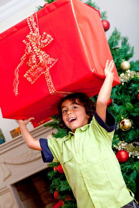 Little Boy Carrying A Christmas Present And Smiling Freestock Photos