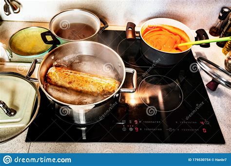 Preparing Meals In Pots On Hot Cooktop In Kitchen Stock Photo Image