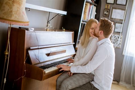 Lovely Young Couple Playing The Piano Together At Home Photo Free