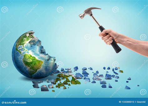 A Male Hand Holds A Metal Hammer Near A Semi Broken Earth Globe With