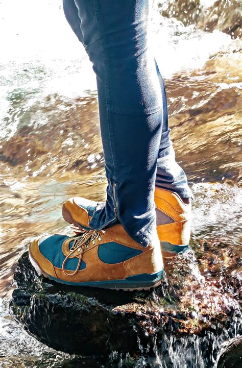 a person standing on top of a rock next to a river with water running over it