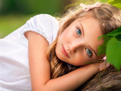 Ash Eyes Cute Little Girl Is Lying On Tree Trunk Wearing White Dress In