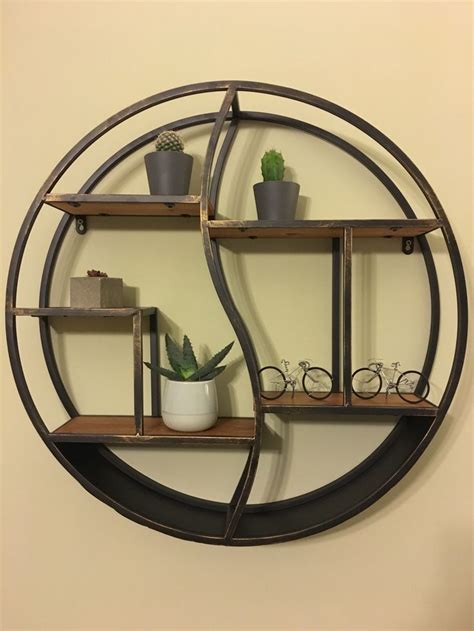 A Circular Metal Shelf With Two Shelves Holding Plants