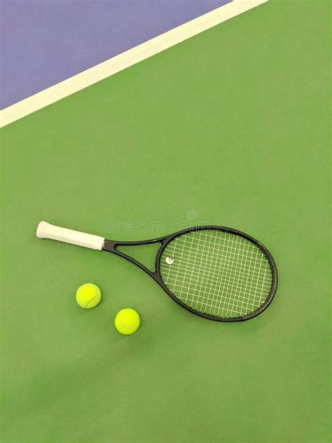 Top View Of Tennis Racket And Two Balls On The Green Clay Tennis Court