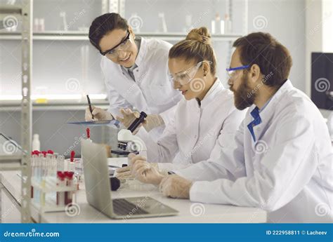 Group Of Young Scientists Working In A Modern Pharma Or Biotech Science