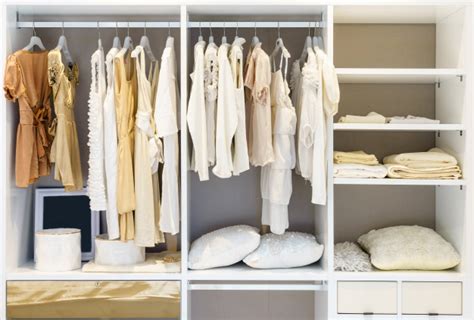 Closet systems keep your items tidy and organized. Modern wooden wardrobe with clothes hanging on rail in ...