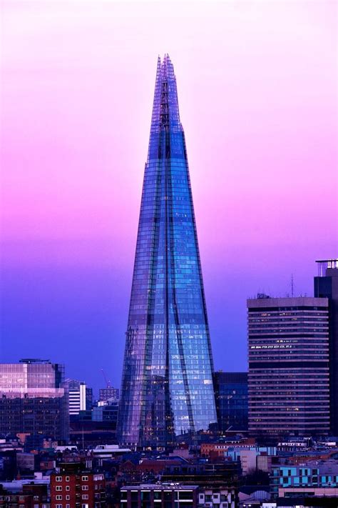 The Shardle Building In London Is Lit Up At Night With Pink And Purple