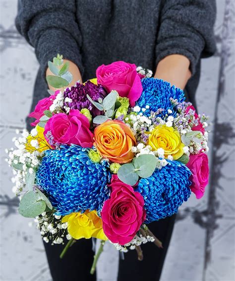 A Woman Holding A Bouquet Of Colorful Flowers