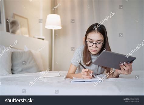 Cute Teenager Girl Doing Homework Lying On Bed At Home Young Pretty