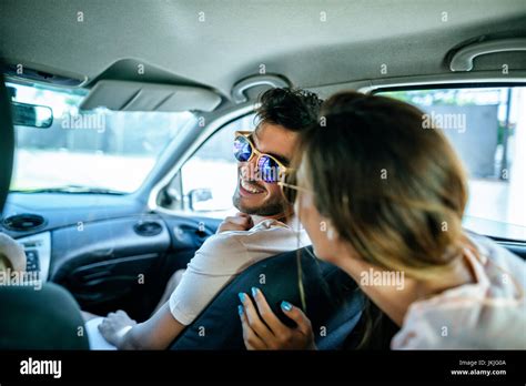 Man In Passenger Seat Of A Car Talking To A Woman From The Backseat