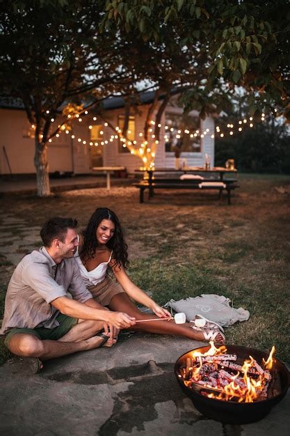 Premium Photo Lovely Couple Roasting Marshmallows In A Backyard