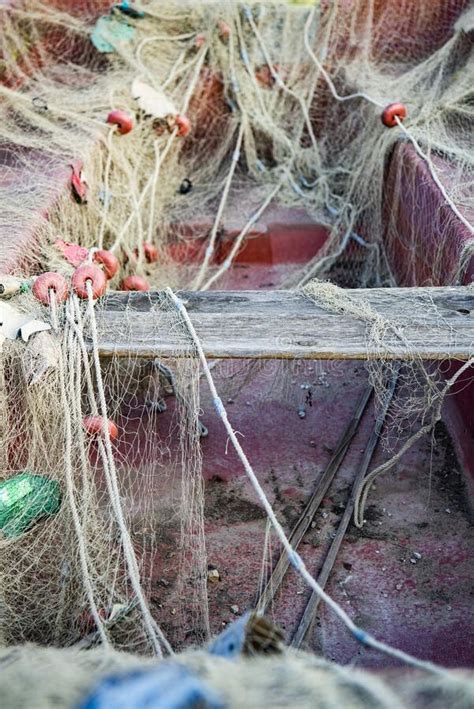 Vertical Shot Of An Old Boat Covered With A Fishing Net Stock Image