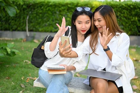 Two Attractive Asian Millennial College Women Having A Video Call With Her Friends Stock Image