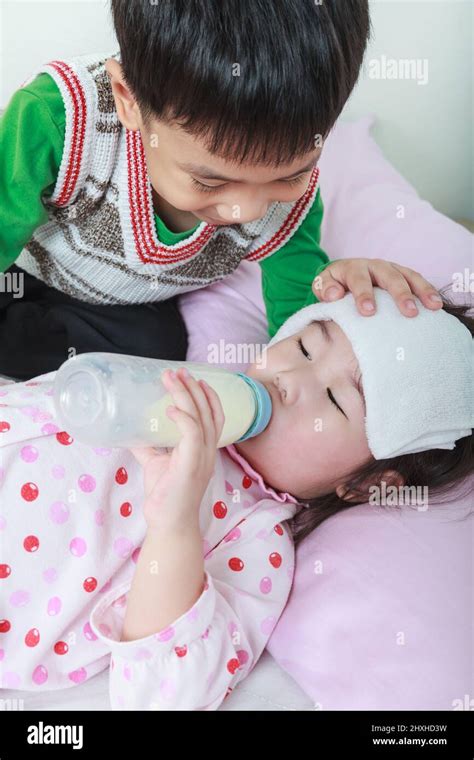Sick Sister Lying And Suck Up Milk On The Bed Kindly Brother Keep Vigil Over A Sick Of Closely