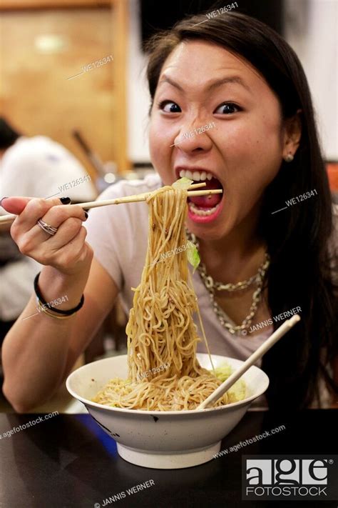 Young Asian Girl Eating Chinese Noodle Dish At A Restaurant In Chinatown Manhattan New York Ny