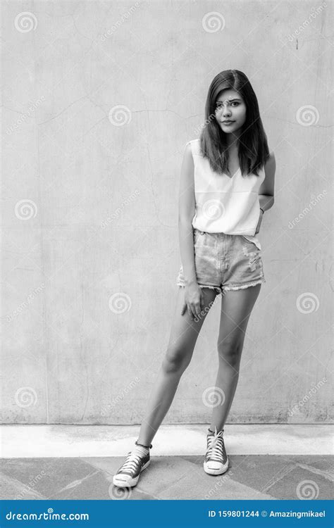 Full Length Portrait Of Beautiful Teenage Girl Standing Outdoors Stock