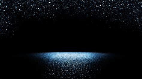 Twinkling Blue Glitter Falling On A Flat Surface Lit By A Bright