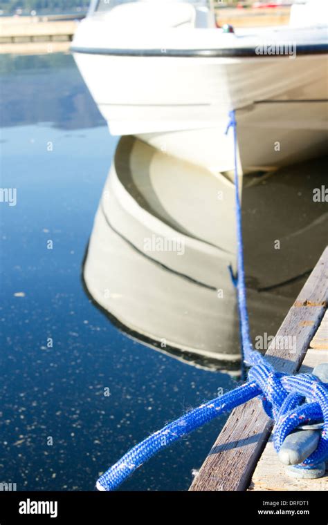 Boat Tied Up On A Wooden Dock With Blue Rope Stock Photo Alamy