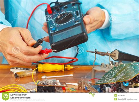 Serviceman Checks Board Of Electronic Device With A Multimeter Stock