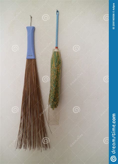 Duster And Broom Stick Hanging On The Wall Of The House Stock Photo