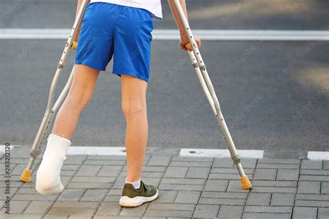 Childhood Injuries Young Boy In Orthopedic Cast On Crutches Walking On